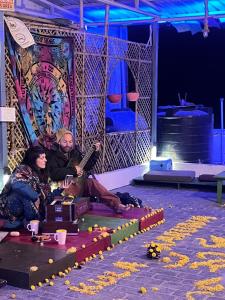 um grupo de pessoas sentadas no palco em Joey's Homestay em Rishikesh