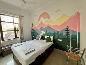 um quarto com uma cama com um mural de montanha na parede em Joey's Homestay em Rishikesh