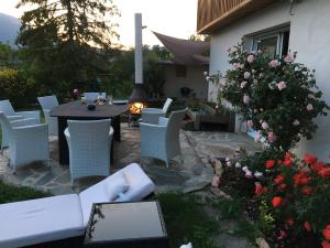 eine Terrasse mit einem Tisch, Stühlen und Blumen in der Unterkunft Chambre chez l'habitant in Châteauvieux