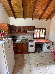 a kitchen with wooden cabinets and a white refrigerator at Haus Independencia Guara Paraguay 