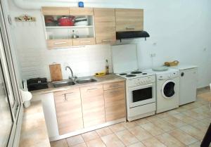 a kitchen with a stove and a washing machine at House of South in Yiannioú