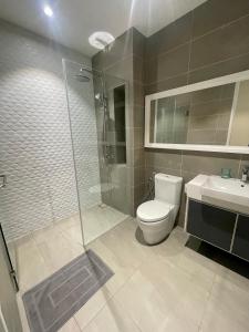 uma casa de banho com um chuveiro, um WC e um lavatório. em Quill Residences em Kuala Lumpur