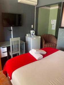 a bedroom with a bed with a red blanket on it at Marion Lodge in Johannesburg