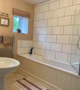 a bathroom with a bath tub and a sink at Hob Lane Farm Cottage in Oughtibridge