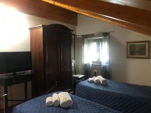 a bedroom with two beds with white towels on them at Il Vecchio Noce in Brugnato