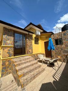 a set of stairs leading to a house with a patio at Beautiful & Secured yellow House for 2 - Center of Osu in Accra