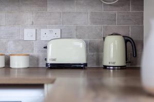 dos tostadoras sentadas en un mostrador en una cocina en The Brent Park Collection, en Londres