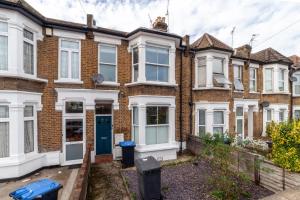 una fila de casas de ladrillo con una puerta azul en The Brent Park Collection, en Londres