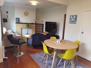 un soggiorno con tavolo, sedie e divano di Epsom Red House ad Auckland