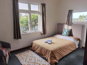 una camera da letto con un letto e un animale di peluche di Epsom Red House ad Auckland