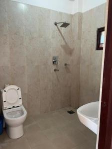 a bathroom with a toilet and a tub and a sink at Sauraha BnB in Sauraha