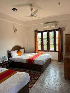 sypialnia z 2 łóżkami i oknem w obiekcie Sauraha BnB w mieście Sauraha