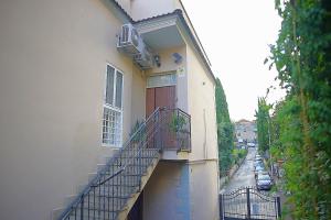 an apartment building with a staircase leading up to a door at Eva Capital Guest House in Vitinia