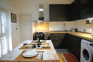 una cocina con una mesa con platos y copas de vino en Eva Capital Guest House, en Vitinia