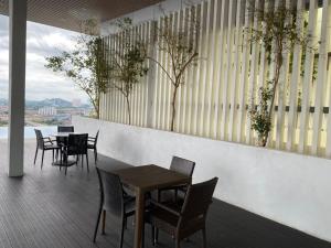 ein Restaurant mit Tischen und Stühlen auf einem Balkon in der Unterkunft Damen Suite (A) Sunway Subang by DW in Subang Jaya