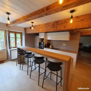 a kitchen with a bar with stools around it at Gite le petit Québec 