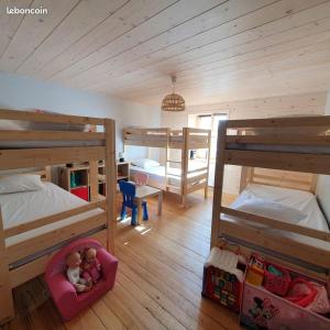 a bedroom with two bunk beds and two dolls in a chair at Gite le petit Québec 