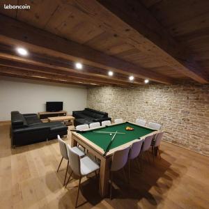 a room with a pool table with chairs and a couch at Gite le petit Québec 