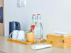 a wooden tray with bottles and cups on a table at Somatepy Boutique Hotel in Phumĭ Thnál