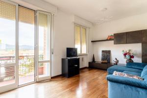 a living room with a blue couch and large windows at Roomy Flat near the Hospital Riuniti with Parking! in Livorno