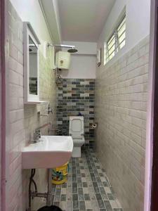 a bathroom with a sink and a toilet at Ejam House, with a tea garden view in Darjeeling