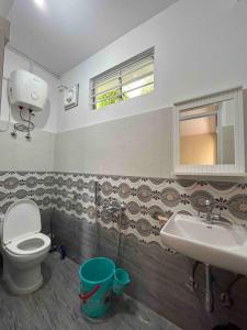 a bathroom with a toilet and a sink at Ejam House, with a tea garden view in Darjeeling