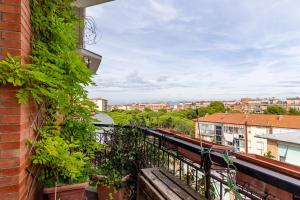a balcony with plants and a view of a city at Roomy Flat near the Hospital Riuniti with Parking! in Livorno