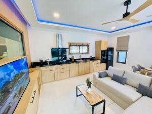 a living room with a white couch and a tv at Yuka residence in Koh Samui