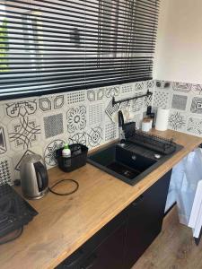 un bancone della cucina con lavandino e tastiera di Mały Apartament - Wierzbiny numer 2 a Wierzbiny