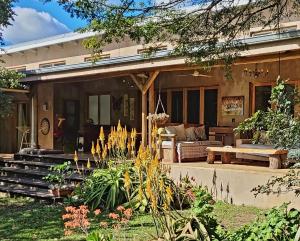 ein Haus mit einer Veranda mit einem Sofa und einem Tisch in der Unterkunft Tchagra House in Hluhluwe