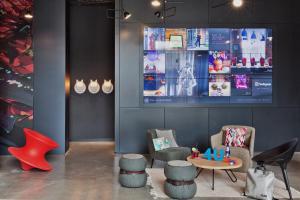 a room with chairs and a table and a tv at Moxy Tbilisi in Tbilisi City