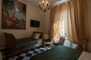 1 dormitorio con 2 camas y lámpara de araña en Morali Palace, en Génova