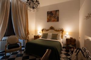 a bedroom with a bed and a chair and a chandelier at Morali Palace in Genoa