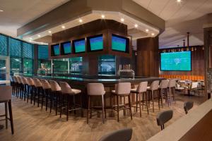 a bar in a restaurant with chairs and tables at Sheraton Arlington Hotel in Arlington