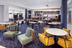 a restaurant with tables and chairs and a bar at Courtyard by Marriott Charleston Downtown/Civic Center in Charleston