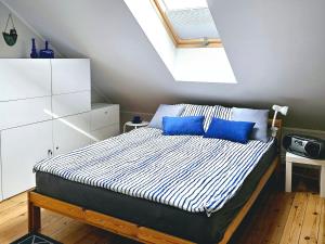 1 dormitorio con 1 cama con almohadas azules en Oliwkowa Przystań, en Mechelinki