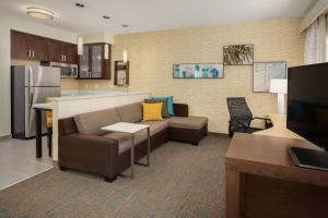 a living room with a couch and a kitchen at Residence Inn by Marriott Shreveport-Bossier City/Downtown in Bossier City