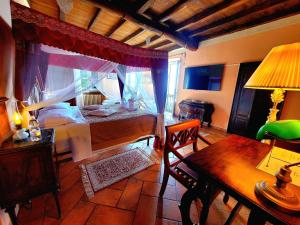 a bedroom with a bed and a desk and a table at Antica Locanda La Tinara del Belvedere - Romantic Dreams - in Galbiate