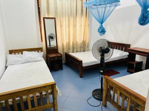 una camera con due letti e un ventilatore di LOTUS HOLIDAY REST a Anuradhapura