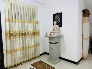 una stanza con una statua su un tavolo e tende di LOTUS HOLIDAY REST a Anuradhapura