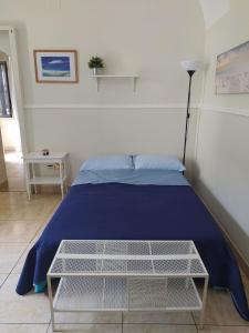 Un dormitorio con una cama azul y una mesa en Palma House en Catania