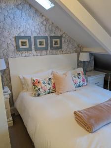 1 dormitorio con 1 cama blanca grande con almohadas en The Bridges B&B en Broomhill