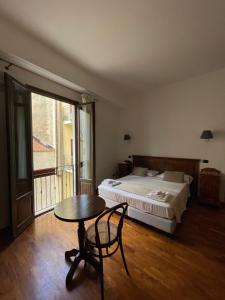 - une chambre avec un lit, une table, un lit et une fenêtre dans l'établissement Hotel La Piazzetta, à Castellammare del Golfo