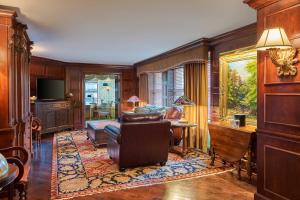 uma sala de estar com paredes de madeira, um sofá e uma mesa em The Brown Palace Hotel and Spa, Autograph Collection em Denver