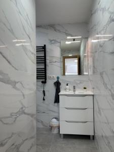 uma casa de banho branca com um lavatório e um espelho em Apartamentos Laborde em Madri