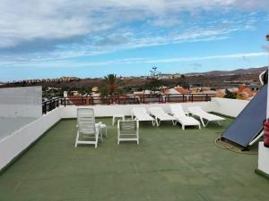 een groep stoelen op een dak bij Villa las Buganvillas MASPALOMAS - Cocina y habitaciones con baños privados in Maspalomas