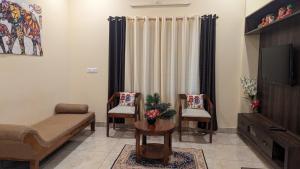 ein Wohnzimmer mit Sofa und Fernseher in der Unterkunft SindooRa in Mysore
