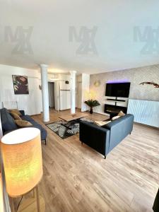 a living room with a couch and a television at El Cubanito Athéna - Résidence de Standing - 2 Chambres - Parking Privé - Gare à 8 min in Cergy