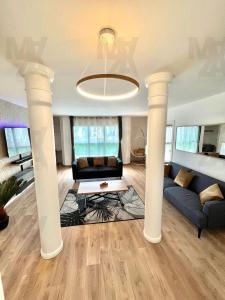 a living room with columns and a couch at El Cubanito Athéna - Résidence de Standing - 2 Chambres - Parking Privé - Gare à 8 min in Cergy +38 photos