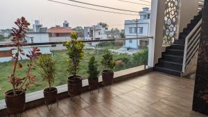een balkon met potplanten en trappen in een gebouw bij SindooRa in Mysore
